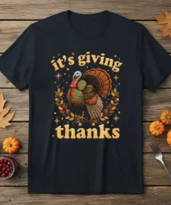 Thanksgiving t-shirt with "it's giving thanks" text and a colorful turkey graphic surrounded by autumn leaves and stars