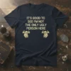 Navy t-shirt with gold text "IT'S GOOD TO SEE I'M NOT THE ONLY UGLY PERSON HERE" and two small gargoyle