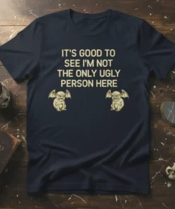 Navy t-shirt with gold text "IT'S GOOD TO SEE I'M NOT THE ONLY UGLY PERSON HERE" and two small gargoyle