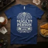 Dark blue t-shirt with white text that reads "IT'S GOOD TO SEE I'M NOT THE UGLY PERSON HERE" featuring a