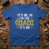 Blue t-shirt with white and yellow text "IT'S ME, HI. I'M THE DAD IT'S ME" featuring gear and wrench graphics
