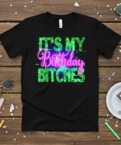 Black t-shirt with neon green and pink text reading "IT'S MY Birthday BITCHES" in a bold, retro font