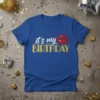 Blue t-shirt with "it's my BIRTHDAY" text in white and gold glitter, featuring red glitter lips and stars