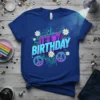 It's My Birthday text with retro neon design, peace signs, and daisies on a blue t-shirt