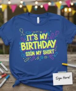 Blue t-shirt with bright yellow and pink text that reads "IT'S MY BIRTHDAY SIGN MY SHIRT", surrounded by birthday graphics