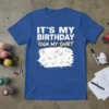 Blue t-shirt with white text "IT'S MY BIRTHDAY SIGN MY SHIRT" and a white paint splatter graphic filled with signatures