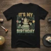 It's My Birthday text with a sloth wearing a party hat, cake, monkey, and toucan on a black t-shirt design