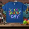 Royal blue t-shirt with colorful "IT'S MY BIRTH DAY" text, confetti, and spray paint graphics