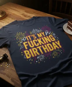 Navy t-shirt with "IT'S MY FUCKING BIRTHDAY" in large yellow text, surrounded by colorful fireworks and confetti