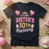 It's My Sister's 10th Birthday text with crown, balloons, and cakes graphic on a dark t-shirt