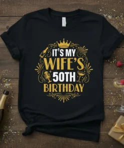 It's My Wife's 50th Birthday text with crown, champagne bottle, microphone, and glasses graphic on a black t-shirt