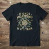 It's Not Hoarding If It's Yarn quote on a dark t-shirt with a yarn ball and knitting needles graphic