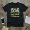 Black t-shirt with yellow text reading "IT'S NOT PARADISE WHEN LOCALS CAN'T AFFORD TO LIVE HERE" over a blue city