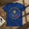 Christian t-shirt with the quote "It's Not Religion It's A Relationship" in yellow text surrounding a glowing cross and floral