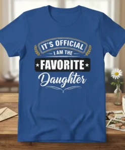 Blue t-shirt with "IT'S OFFICIAL I AM THE FAVORITE Daughter" text in a playful, bold font, laurel wreath accents