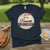 Navy blue t-shirt with "IT'S OFFICIAL I AM THE Favorite GRANDSON" text in a circular vintage design, perfect for favorite
