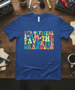 Retro wavy text design that reads "IT'S OFFICIAL I AM THE FAVORITE GRANDSON" with colorful accents and a skull graphic