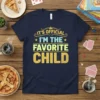 Navy blue t-shirt with the text "IT'S OFFICIAL I'M THE FAVORITE CHILD" in bold, distressed yellow and green lettering, styled