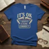 Blue t-shirt with "IT'S OK I IDENTIFY AS BEING CORRECT" in distressed yellow and white text, featuring decorative banners and