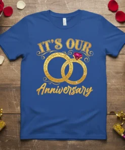Blue t-shirt with gold text "IT'S OUR Anniversary" and intertwined gold rings with a ruby gemstone