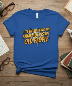 Blue t-shirt with yellow and orange comic-style text "IT'S WEIRD BEING THE SAME AGE AS OLD PEOPLE" for a funny