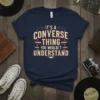 Navy blue t-shirt with distressed text that reads "IT'S A CONVERSE THING YOU WOULDN'T UNDERSTAND" in a vintage badge design