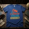 T-shirt with bold text "IT'S A GOOD DAY TO DEFEND DEMOCRACY" featuring a torch and flag graphic