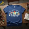 It's a good day to teach TINY humans text with apple, rainbow, books, and pencil graphics on a blue t-shirt