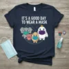 T-shirt with the text "It's A Good Day To Wear A Mask" and cartoon elephant, pig, egg, and bird wearing