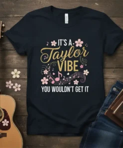 Black t-shirt with "It's a Taylor Vibe You Wouldn't Get It" text in gold and white, surrounded by musical notes