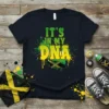 It's IN MY DNA text with Jamaican flag map graphic, green and yellow splatter design, on a navy t-shirt