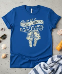 I've Got My Swim Trunks & My Flippy Floppies quote on a royal blue t-shirt, featuring a graphic of patterned