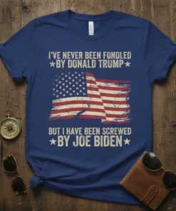 Political t-shirt with distressed American flag graphic and the text "I've Never Been Fondled By Donald Trump But I Have