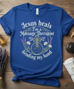Blue t-shirt with white text "Jesus heals I'm a Massage Therapist Sending my hand" and a cross graphic with floral