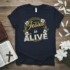 Jesus is ALIVE Christian t-shirt with gold text, halo, and floral wreath design