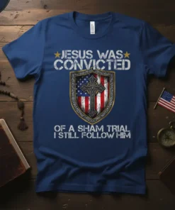 Blue t-shirt with "Jesus Was Convicted Of A Sham Trial I Still Follow Him" text, featuring a shield with the