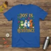Joy is Resistance slogan t-shirt with a frog, chicken, shark, and dinosaur characters, surrounded by flowers and confetti