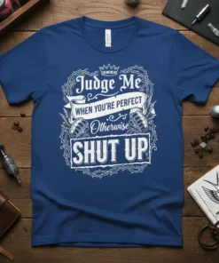 White text "Judge Me WHEN YOU'RE PERFECT Otherwise SHUT UP" on a navy blue t-shirt, with thorny border and fist
