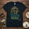 June 12th Birthday Girl text with a golden crown and sparkling teal and green letters on a black t-shirt