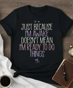 Black t-shirt with colorful text that reads "JUST BECAUSE I'M AWAKE DOESN'T MEAN I'M READY TO DO THINGS"