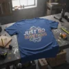 Blue t-shirt with "JUST DO SOMETHING" text in orange and white, featuring blueprint-style graphics and gears