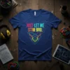 Blue t-shirt with colorful text "JUST LET ME STIM BRO." and geometric design, promoting autism awareness