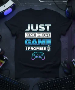 T-shirt with "JUST ONE MORE GAME I PROMISE" text, a controller graphic, and a finger-crossing icon