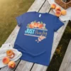 Blue t-shirt with "JUST Peachy" text, featuring a graphic of three peaches and blooming cherry blossoms