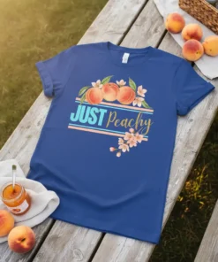 Blue t-shirt with "JUST Peachy" text, featuring a graphic of three peaches and blooming cherry blossoms