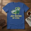 Blue t-shirt with yellow text "JUST RESTING MY EYES" and a cartoon of a person sleeping in an ornate chair