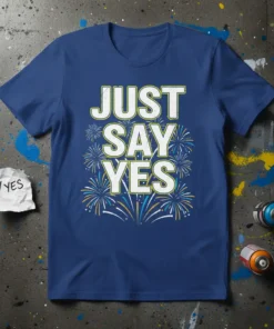 Blue t-shirt with white and yellow text "JUST SAY YES" surrounded by colorful fireworks graphic