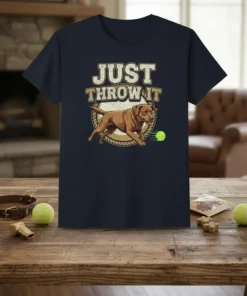 T-shirt design featuring the text "JUST THROW IT" above a running Labrador Retriever chasing a tennis ball
