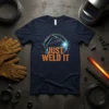 Navy t-shirt with "JUST WELD IT" text and a robotic arm welding graphic, sparks flying, suitable for welders