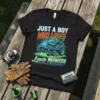 Black t-shirt design featuring bold text "JUST A BOY WHO LOVES" above a detailed illustration of a zero-turn lawn mower